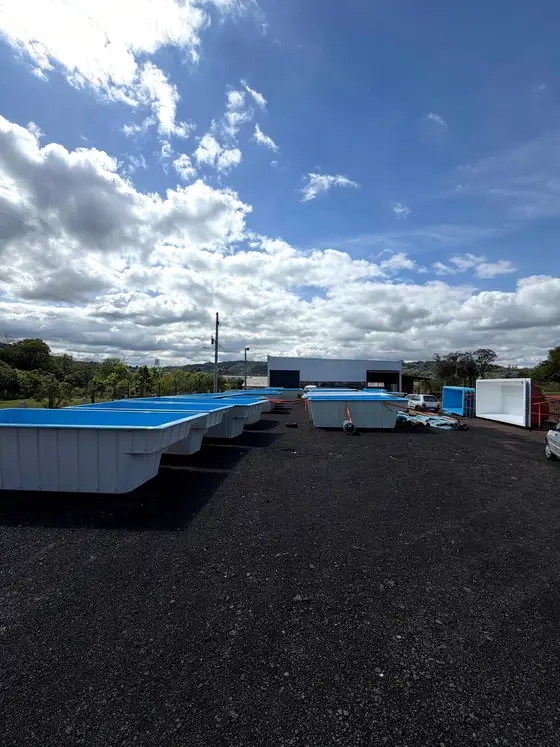 Piscinas azuis alinhadas no pátio da Fiberlux